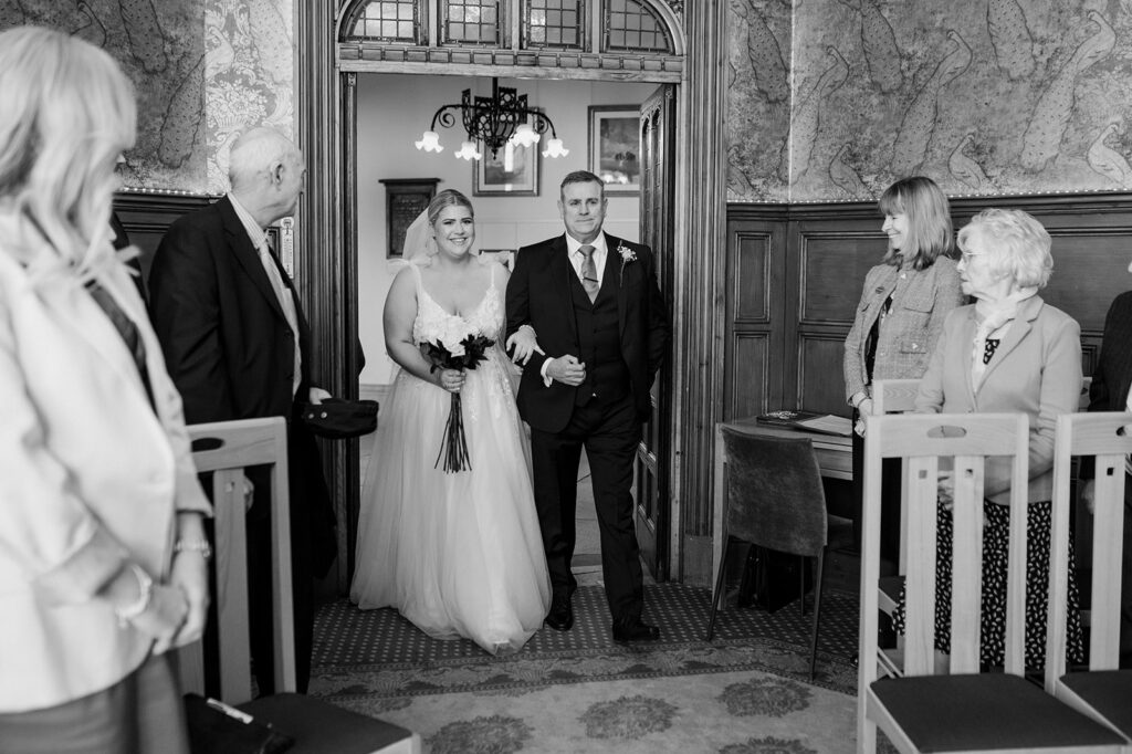 Intimate Winchester registry office wedding. A bride walking down the aisle with her dad