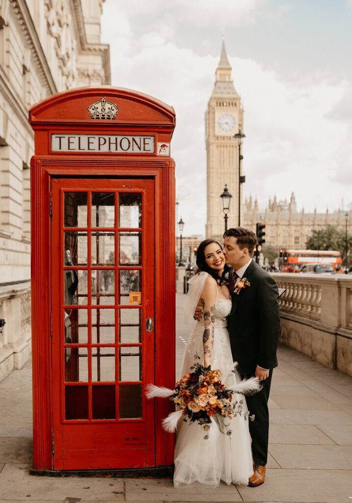 Iconic London wedding portrait with a red telephone box and Big Ben