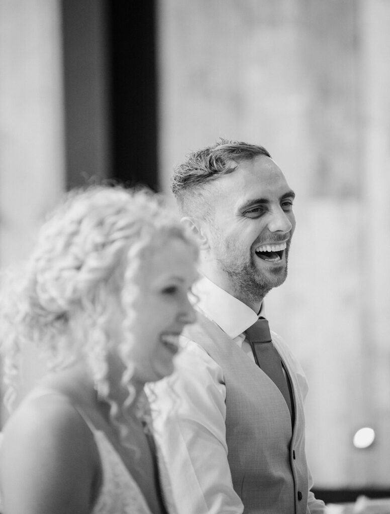 Candid laughing wedding photography during speeches