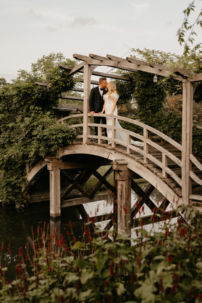 A couple standing on the bridge at Great Fosters wedding venue