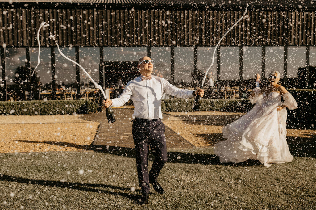 Champagne spray at Primrose Hill Farm wedding venue in the Cotswolds