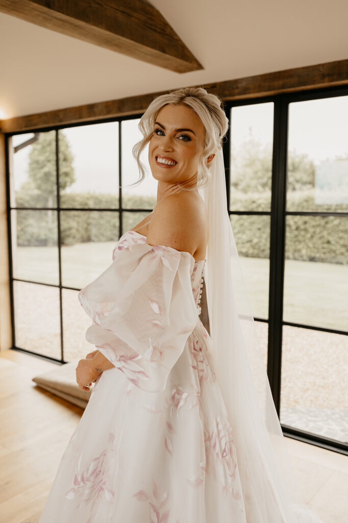 A bride wearing a House of Savin wedding dress with painted flowers