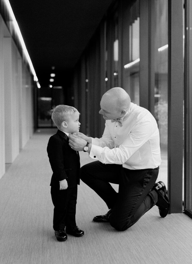 Cute photo of a groom doing his son's tie on his wedding day