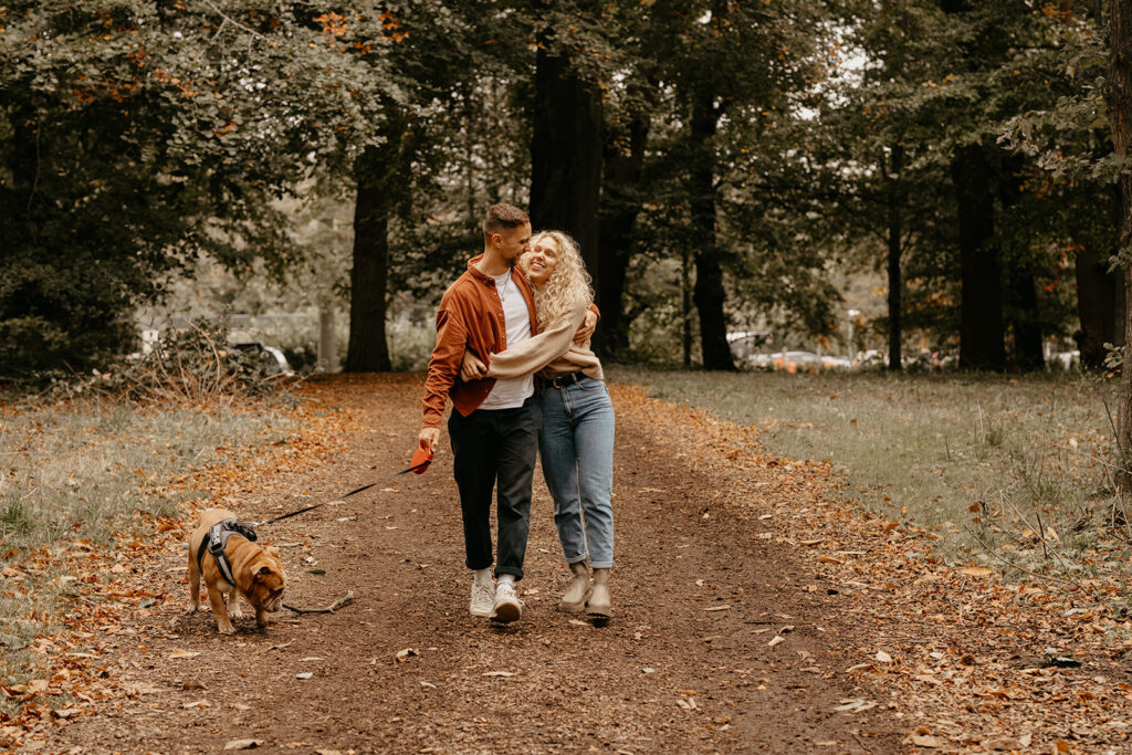 A couple walking in the woods with their dog