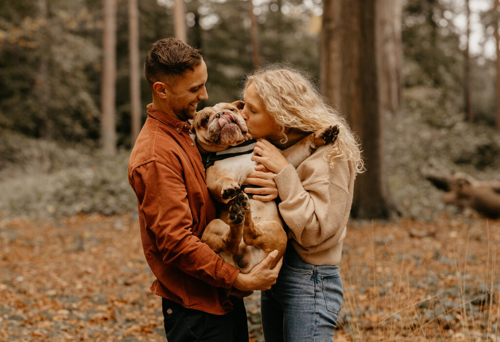 Cute couple photo kissing their dog. Woodland engagement session